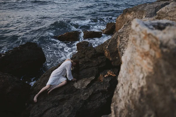 Hermosa novia acostada en la costa rocosa con grietas en la vista de la superficie rocosa desde arriba — Foto de Stock