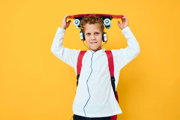 Skolpojke glädje roligt skateboard poserar gul bakgrund — Stockfoto