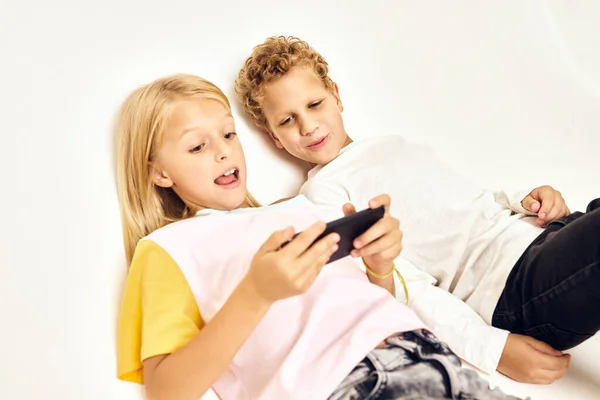 Chico y chica con el teléfono en las manos jugando emociones —  Fotos de Stock