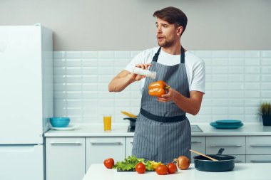 Adam mutfak önlüğü pişiriyor sebze pişiriyor sağlıklı besleniyor