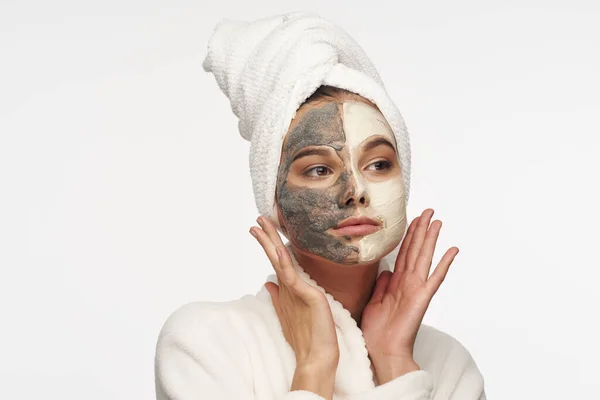 Mujer con toalla en la máscara de cabeza en la cara piel limpia fondo claro —  Fotos de Stock