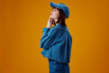 Pozitif genç kadın kot giyim modada poz verme renk arkaplanı değiştirilmemiş