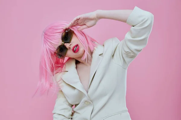 Giovane donna che indossa occhiali da sole capelli rosa posa sfondo di colore inalterato — Foto Stock