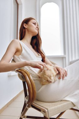 Güzel bir kadın ve kedisi terasta dinlenme konsepti.