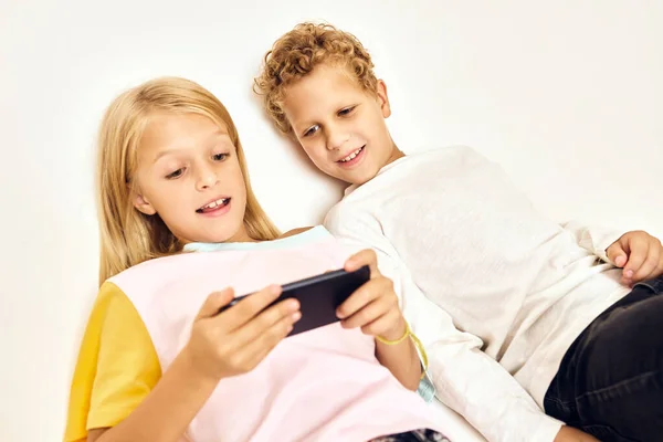 Kleine Kinder mit einem Handy in der Hand spielen — Stockfoto