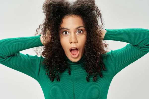 Woman with curly hair and green jacket emotions surprise — Fotografia de Stock