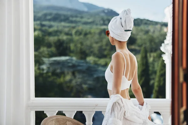 Привлекательный молодой женщины полотенце и солнцезащитные очки на балконе — стоковое фото