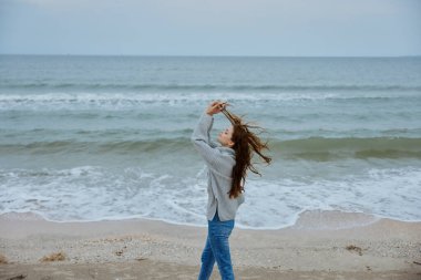 Neşeli kadın kumsalda yürür okyanus özgürlüğüne yolculuk eder Mutlu kadın dinlenir