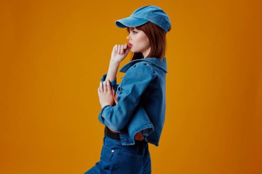 Güzel kadın kot giysisi modada poz verme sarı arkaplan değiştirilmemiş