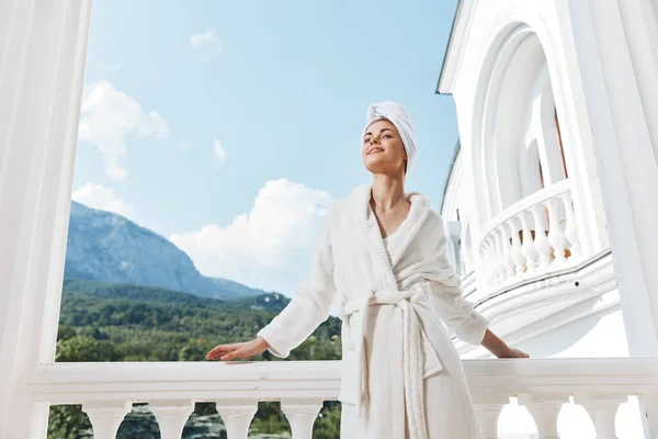 Beautiful woman in a white robe on the balcony bit on green nature Mountain View — Foto Stock