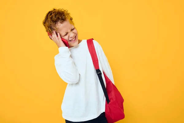 Portrait of a little boy talking on the phone with a school backpack Studio learning concept — Fotografia de Stock