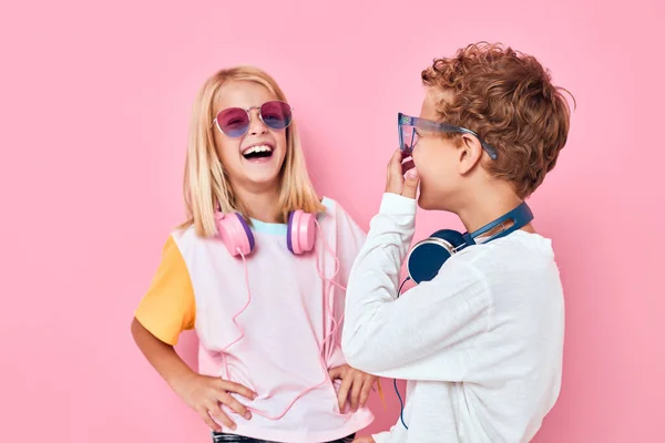 Retrato de una niña y un niño con auriculares posando de moda infantil casual —  Fotos de Stock