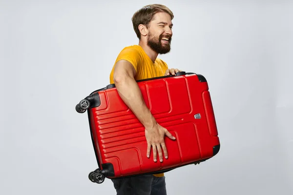 Uomo con valigia rossa viaggio passeggero bagagli — Foto Stock