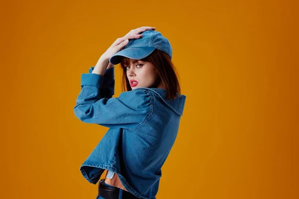 Portrait of a charming lady in a cap and denim jacket posing color background unaltered — Stockfoto