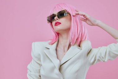 Çekici bir bayan portresi modern tarz pembe saç gözlüğü pembe arka plan değiştirilmemiş.