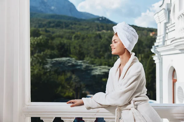 Портрет великолепной женщины, стоящей на балконе и смотрящей на отдых в горах летом — стоковое фото