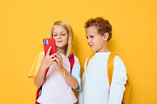 Zwei Kinder Junge und Mädchen, die auf das Telefon Unterhaltung Kommunikation isoliert Hintergrund — Stockfoto