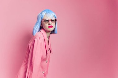 Parlak makyajlı bir kadının portresi. Güneş gözlüğü pembe arka plan.