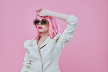 Güneş gözlüğü takan güzel bir kadın pembe saçlı. Arka planda renk değişikliği yok.
