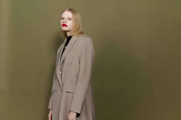 Blonde in coat red lips posing studio models — Foto Stock