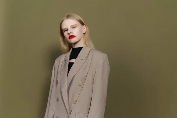 Blonde in coat red lips posing studio models — Stockfoto
