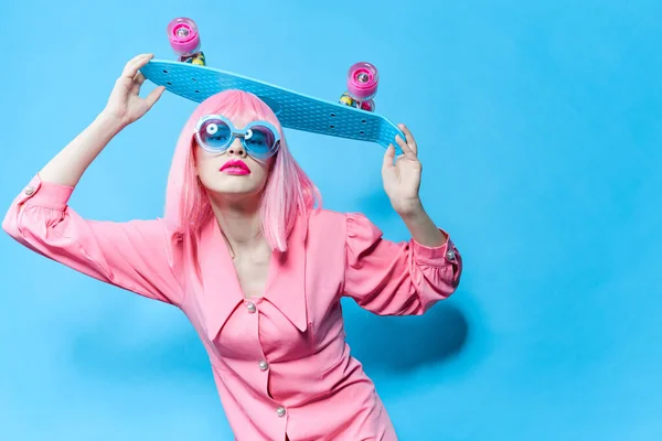 Retrato de una mujer en gafas de sol lleva una peluca rosa modelo de estudio inalterado —  Fotos de Stock