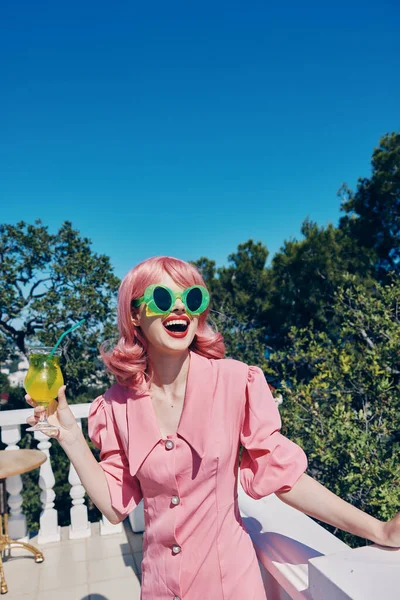 Mulher bonita no vestido rosa óculos verdes bebida refrescante cocktail — Fotografia de Stock