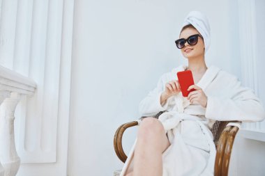 Beyaz cüppeli, siyah gözlüklü neşeli kadın, telefonu kullan.