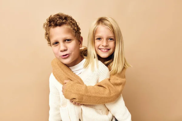 Boy and girl friendship rides on the back childhood beige background — Zdjęcie stockowe
