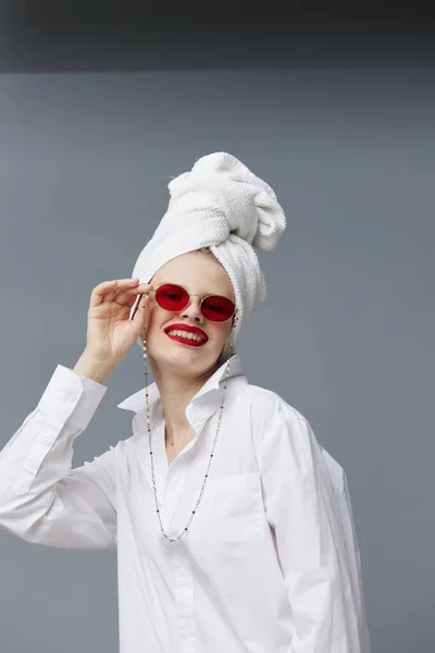 Модная женщина красные очки косметика с полотенцем на голове изолированный фон — стоковое фото