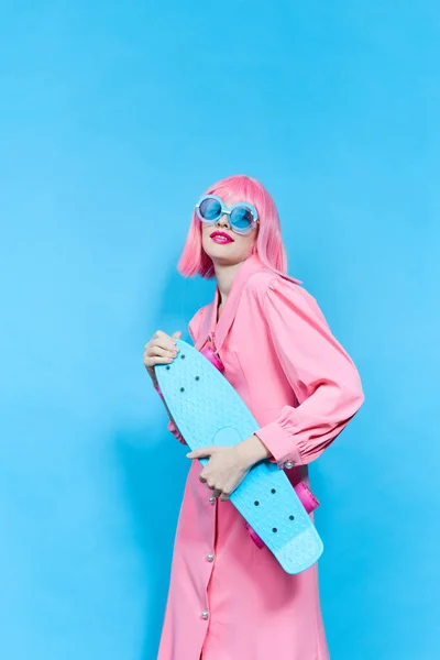Vacker kvinna i solglasögon bär en rosa peruk studio modell oförändrad — Stockfoto