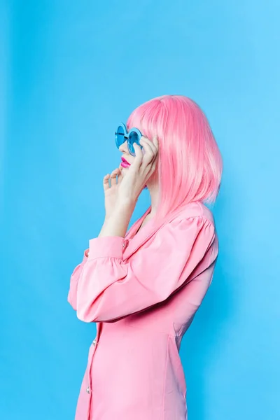 파란색 안경 스튜디오가 있는 핑크 드레스를 입은 매력적 인 여성 — 스톡 사진