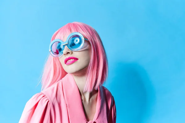 Λαμπερή γυναίκα με μπλε γυαλιά φοράει ροζ περούκα μοντέλο στούντιο αναλλοίωτο — Φωτογραφία Αρχείου