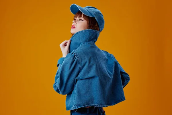 Beautiful fashionable girl in a cap and denim jacket posing studio model unaltered — 图库照片