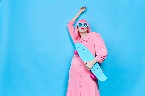 Fashionabla kvinna i solglasögon bär en rosa peruk isolerad bakgrund — Stockfoto