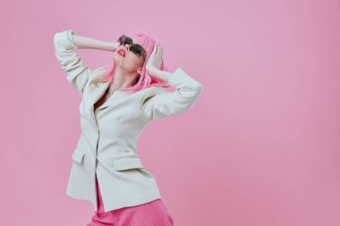 Çekici bir bayan portresi modern tarz pembe saç gözlüğü pembe arka plan değiştirilmemiş.