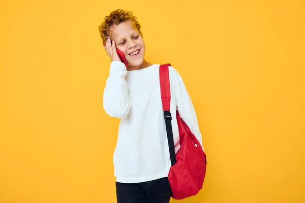 Lächelnder kleiner Junge telefoniert mit einem Schulrucksack — Stockfoto
