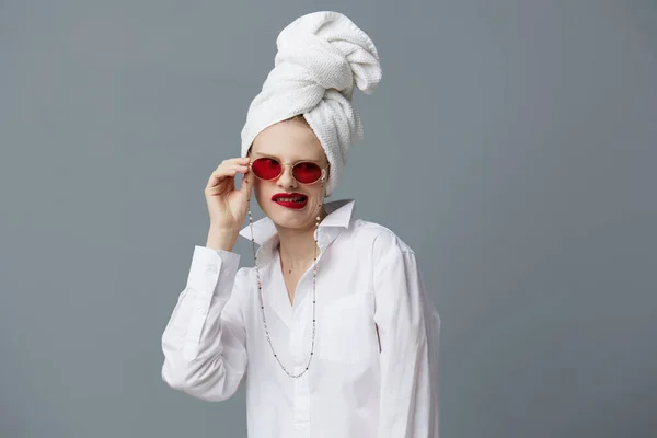 Όμορφη γυναίκα κόκκινα γυαλιά πετσέτα στο κεφάλι μακιγιάζ απομονωμένο φόντο — Φωτογραφία Αρχείου