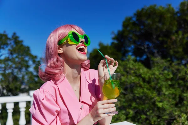 Mulher alegre em óculos de sol verdes com coquetel no verão ao ar livre inalterado — Fotografia de Stock