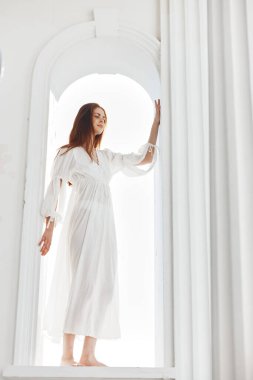 Açılışta beyaz elbiseli kadın kemer şeklinde poz veriyor.