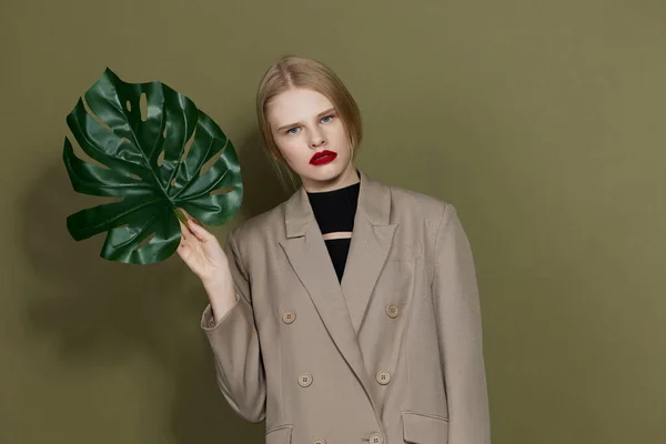 Portrait of a woman in coat red lips fashion palm leaf studio model unaltered — Foto Stock