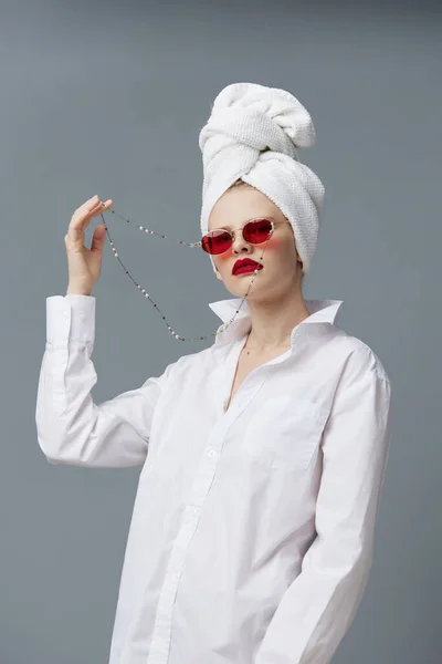 Retrato de una mujer gafas de sol rojas cosméticos con toalla en la cabeza aislado fondo — Foto de Stock