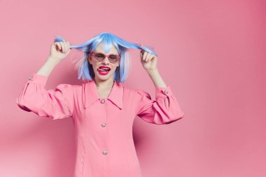 Mavi peruklu kadın. Pembe elbiseli. Kırmızı dudaklı.