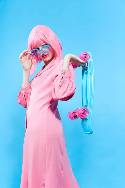 Kvinna med skateboard i rosa peruk studio modell oförändrad — Stockfoto