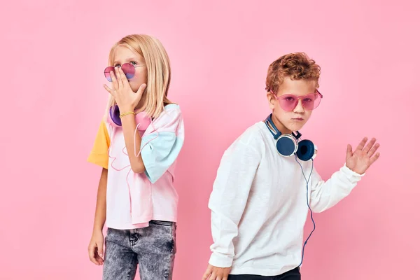 Divertido niño y niña usando auriculares posando escuchar música —  Fotos de Stock