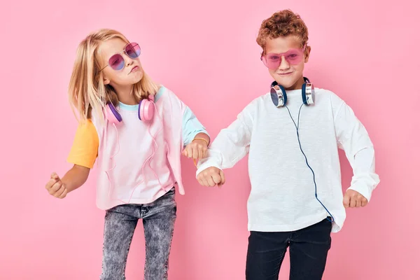 Divertido niño y niña usando auriculares posando concepto de estilo de vida de la infancia —  Fotos de Stock
