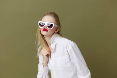 portrait of a woman fashion white shirt sunglasses green background