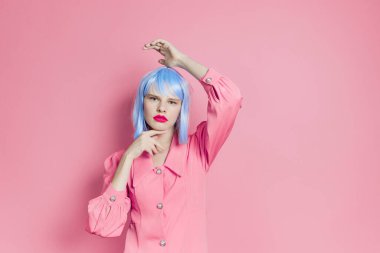 # Mavi peruklu şık bir kadın # # pembe elbiseli, kırmızı dudaklı, pembe arka planlı #