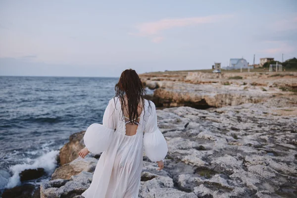 Beyaz elbiseli kadın yaz yürüyüşü okyanus manzarası seyahati — Stok fotoğraf