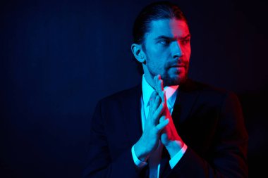 Modadan soyutlanmış kostüm giymiş şık bir adam.